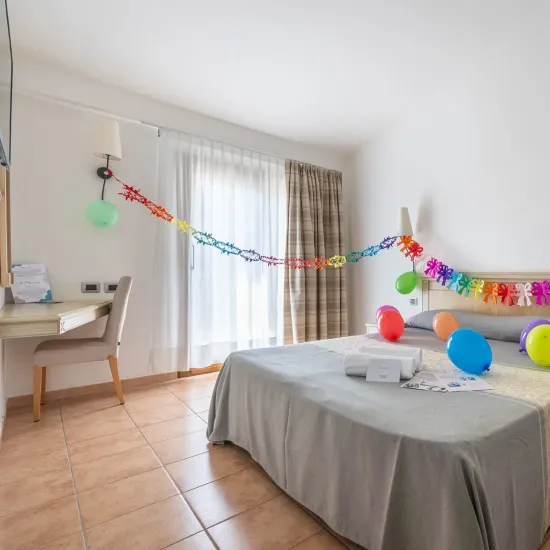 Chambre festive avec ballons colorés et décorations vives.