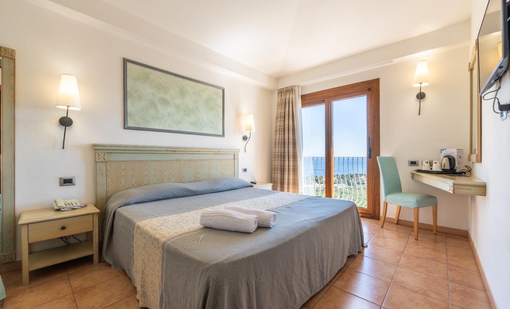 Una camera da letto con un grande letto e vista sul mare con un tocco elegante.