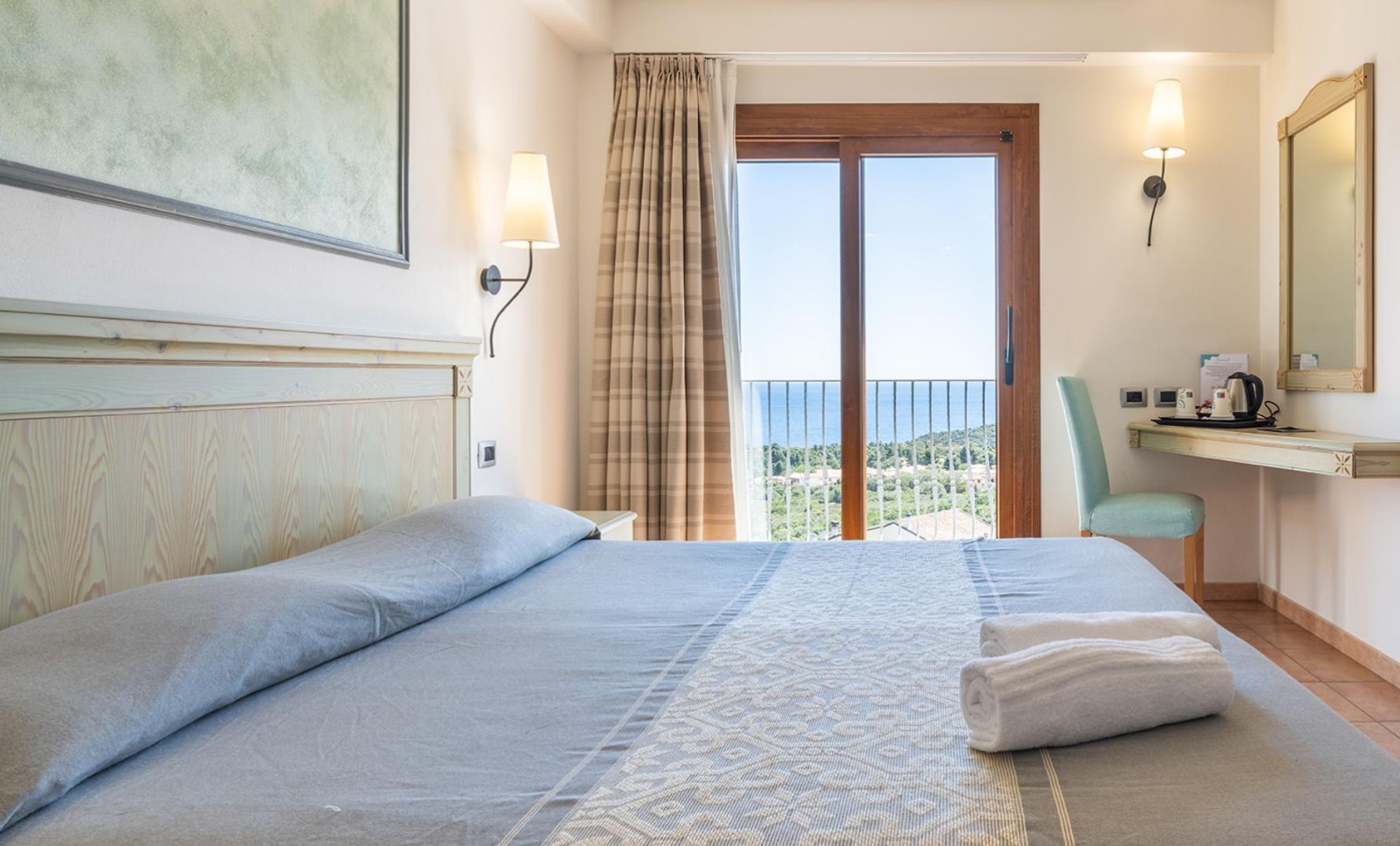 Una camera da letto con un grande letto e vista sul mare con un tocco elegante.