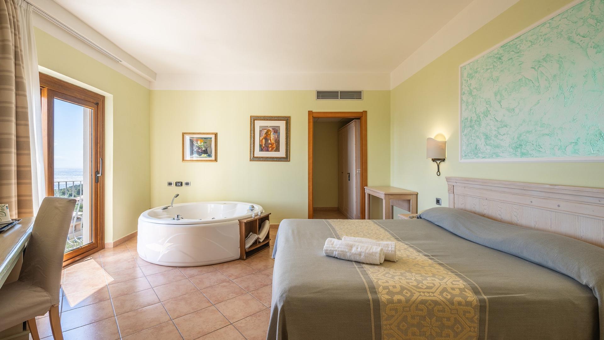 Una camera da letto con un grande letto e una vasca da bagno con dettagli pratici e armoniosi.