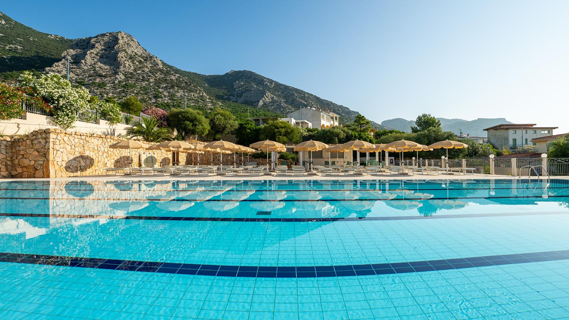 Una piscina con una montagna sullo sfondo dal carattere sereno e rilassante.