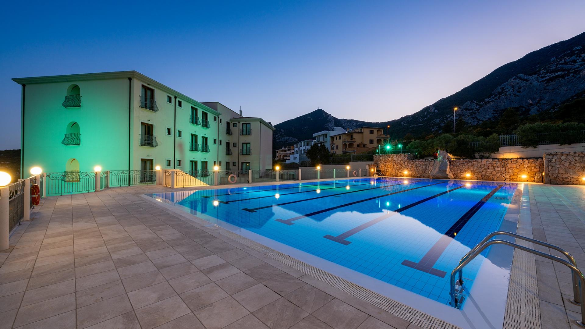 Una piscina con una montagna sullo sfondo dal carattere sereno e rilassante.
