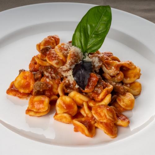 Un piatto di pasta con carne e salsa di pomodoro con una presentazione semplice e curata.