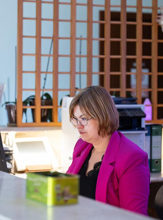 Woman focused on computer, warm and welcoming atmosphere.