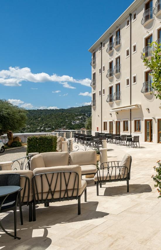 Un cortile con sedie e tavoli in una giornata soleggiata.