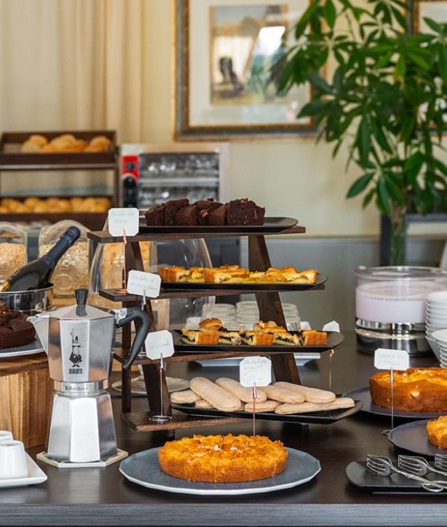 Un tavolo con una varietà di dolci e pasticcini sopra e un’atmosfera accogliente.