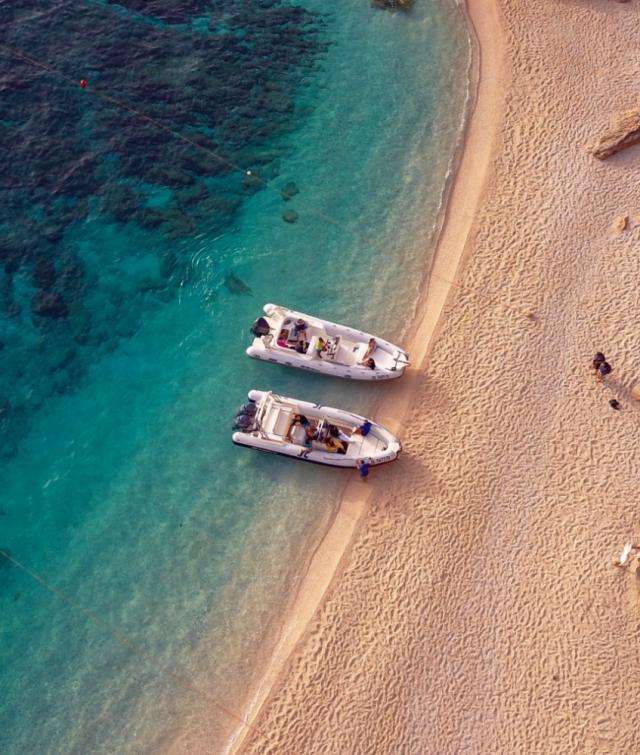 Un paio di barche posizionate in cima a una spiaggia sabbiosa.