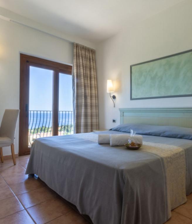 Camera luminosa con vista mare, arredi eleganti e atmosfera rilassante.
