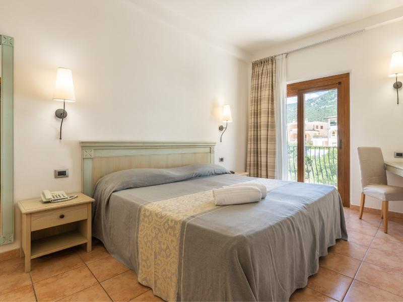 Una camera da letto con un letto e una scrivania con un tocco elegante.