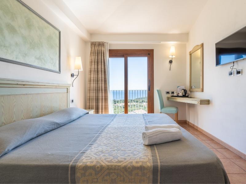 Una camera da letto con un grande letto e un televisore a schermo piatto con colori freschi e invitanti.