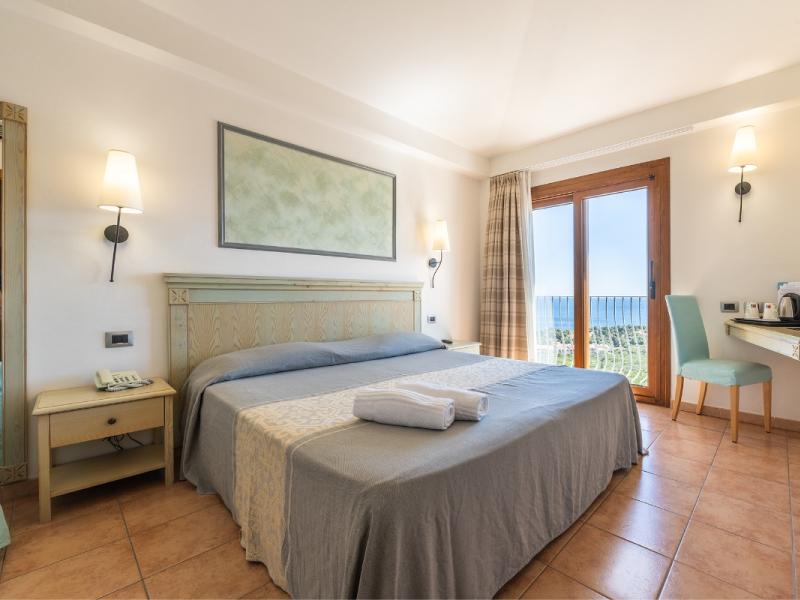 Una camera d'albergo con letto king-size e vista sul mare con un tocco elegante.