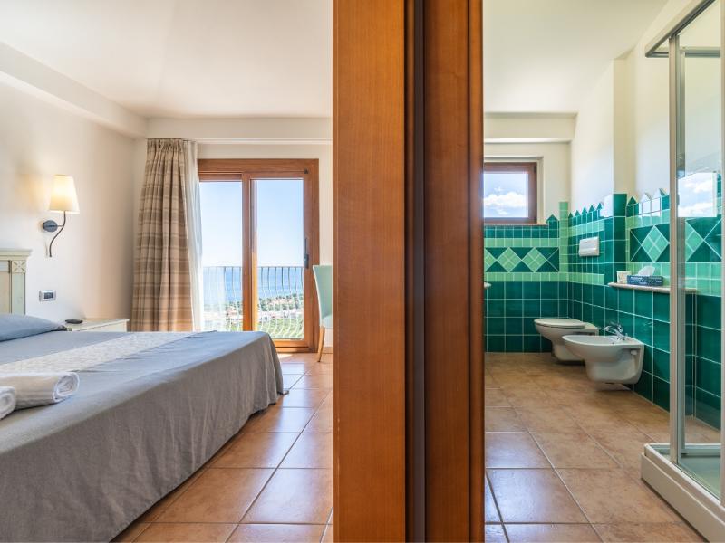 Una camera da letto con un grande letto e vista sul mare con dettagli raffinati e curati.