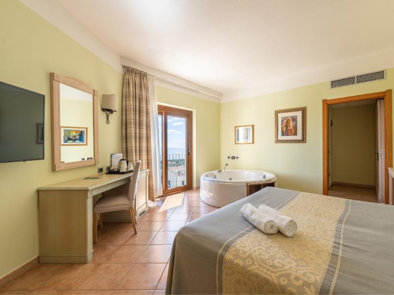 Una camera da letto con un grande letto e un televisore.