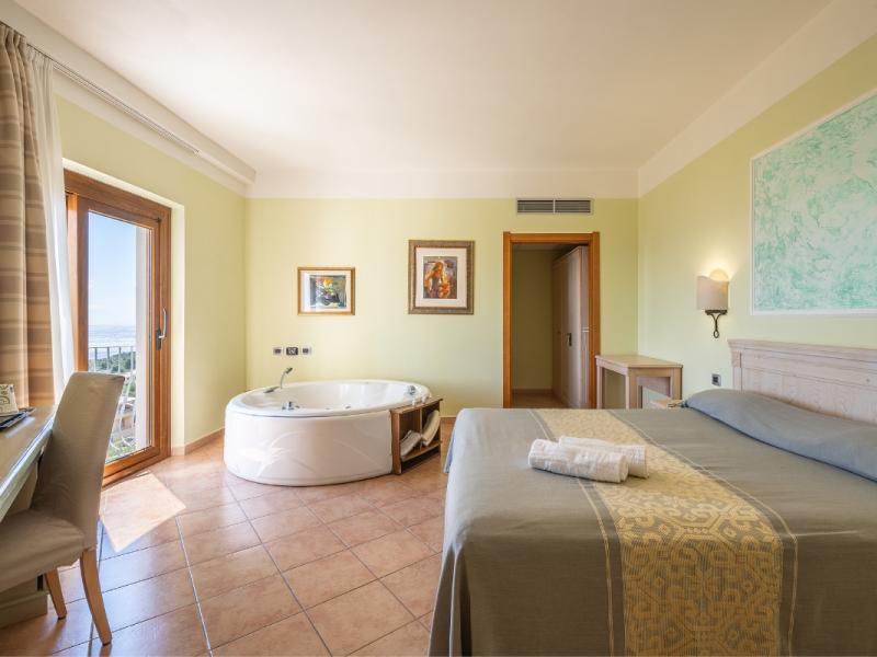 Una camera da letto con un grande letto e una vasca da bagno con dettagli pratici e armoniosi.