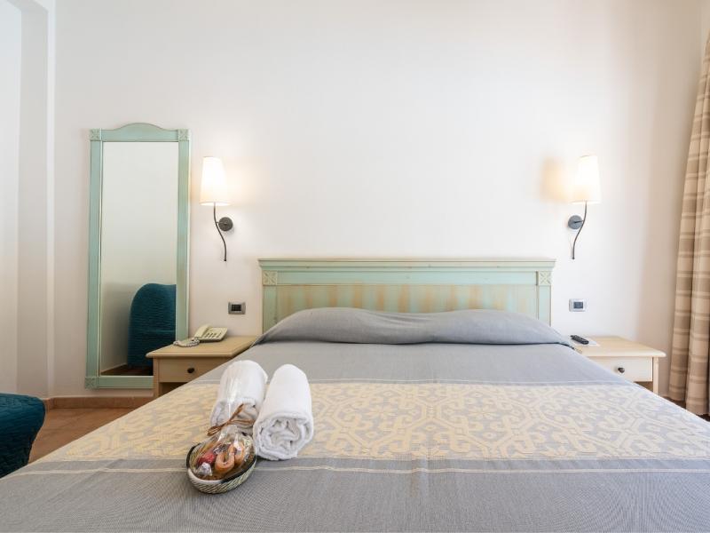 Una camera da letto con un grande letto e una sedia blu con un tocco elegante.