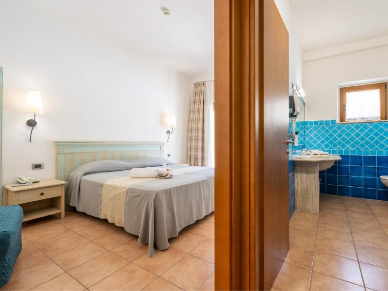 Una camera da letto con un letto e un lavandino dal gusto moderno ed essenziale.