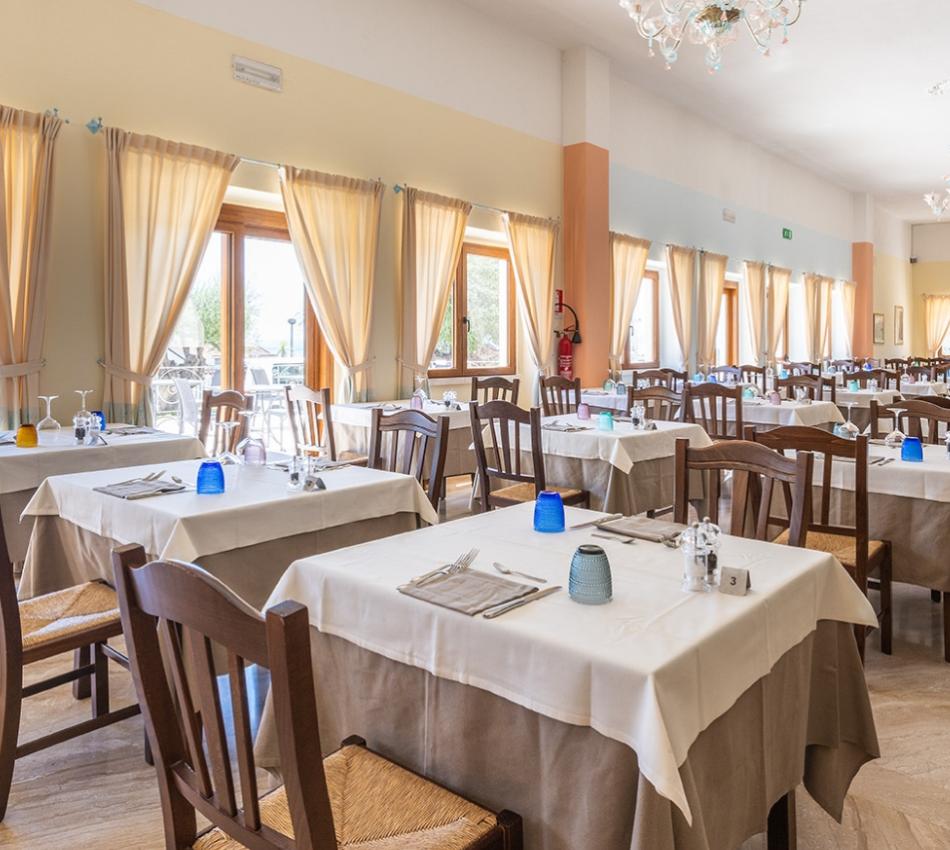 Una sala da pranzo con tavoli e sedie e un candelabro con un fascino accogliente.