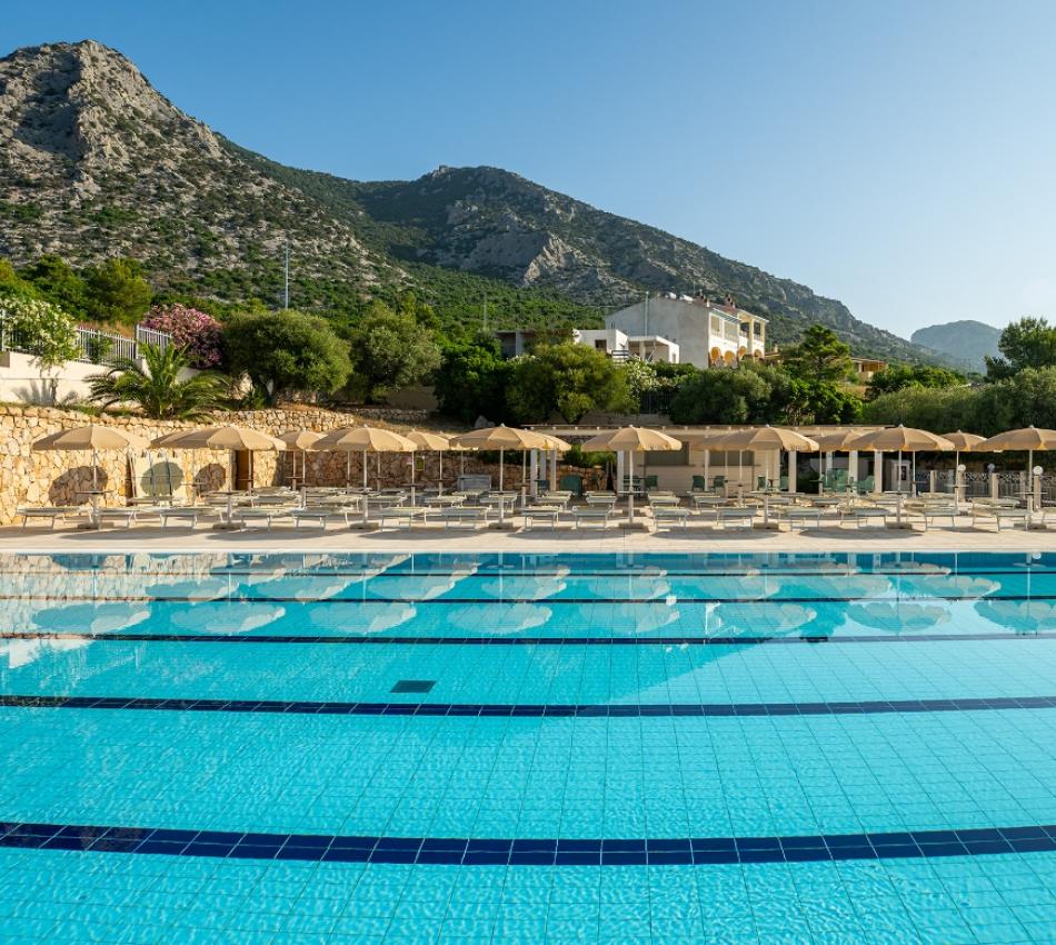 Una grande piscina blu con una montagna sullo sfondo dal carattere sereno e rilassante.